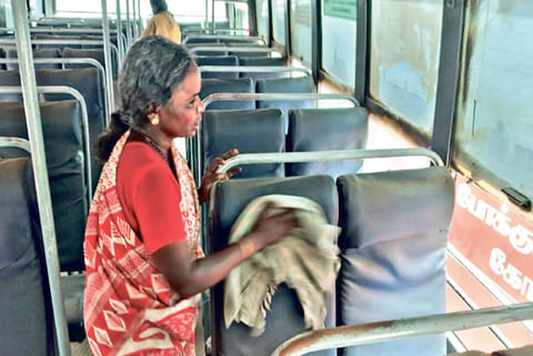 A worker cleans a bus a day ahead of services resumption at Pollachi