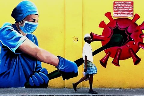 A man walks past a wall mural on Covid-19 awareness in Chennai (Credit: PTI)