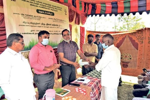 Officials handing cheques to beneficiaries of the NGO sponsored interim relief scheme in Thalavady.