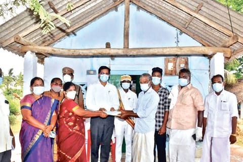 Collector M Govinda Rao handing over the money to Ravichandran in Thanjavur