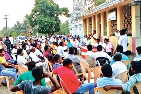 Residents gather in a meeting to protest the government order.