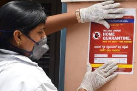 A woman reacts as a healthcare worker collects a swab sample from her (Credit: Reuters)