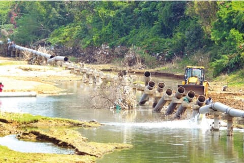 Earthmovers being used to fix the broken water supply pipes across the Palar River