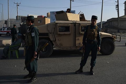 Afghan policemen stand guard near the site where a truck bomb exploded