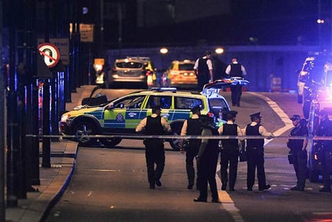 Police officers walk at the scene of an apparent terror attack on London Bridge