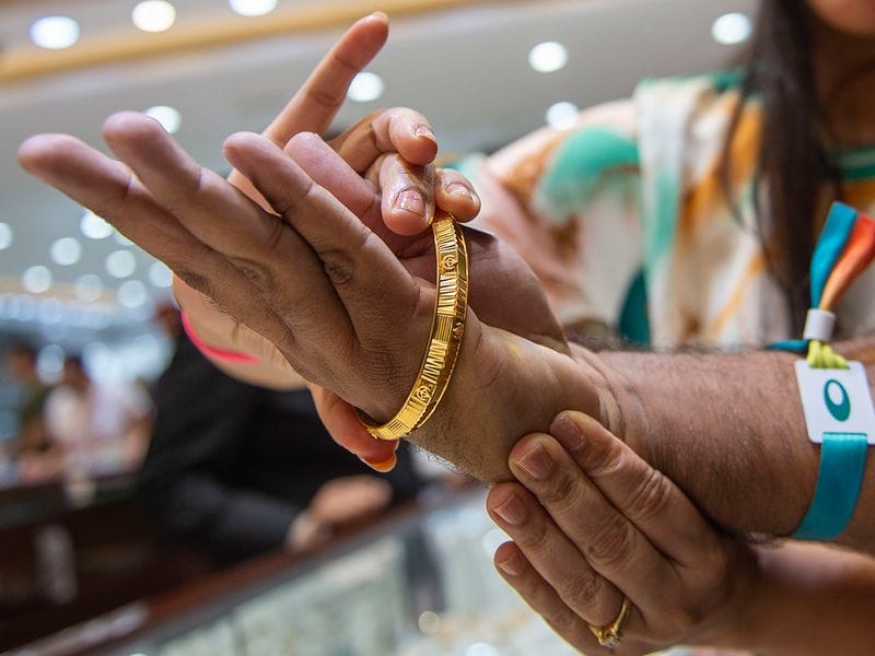Gold necklaces and bangles displayed in a Dubai jewellery shop, reflecting higher local prices amid softer gold rates in India.