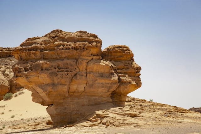 Among the monumental tombs of Hegra, near Jabal Al Ahmar, stands Face Rock — a sandstone formation resembling a human head gazing across the desert. Like many of AlUla’s natural wonders, it was shaped by centuries of erosion. Sunrise and sunset are the best times to visit, when shifting light enhances the illusion and makes the rock appear to glow from within. This striking landmark captivates visitors and photographers, offering a magical glimpse into AlUla’s timeless landscape.