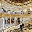 The entrance hall has grand staircases and a dome with handmade glass.
