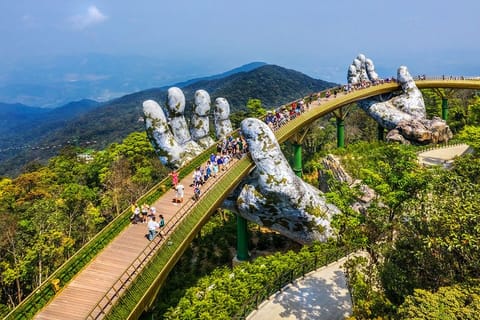 Aerial view of the Golden Bridge lifted by two giant hands in the tourist resort on Ba Na Hill in Da Nang, Vietnam. Ba Na mountain resort is one of top tourist destinations in the country.
