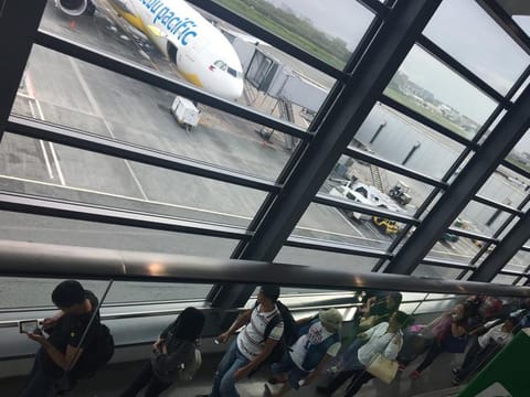 Passengers queue up to board an aircraft at Manila's Ninoy Aquino International Airport