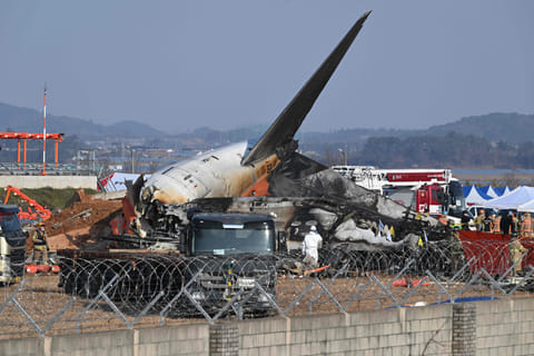 Firefighters and rescue personnel work near the wreckage of a Jeju Air Boeing 737-800 series aircraft after the plane crashed and burst into flames at Muan International Airport in South Jeolla Province.