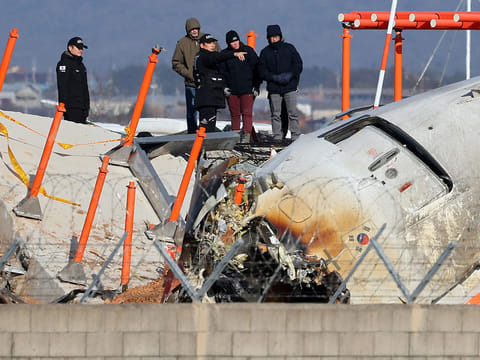 Investigators including officials from South Korea's Aviation and Railway Accident Investigation Board (ARAIB), US National Transportation Safety Board (NTSB) and aircraft manufacturer Boeing,  at the scene where a Jeju Air Boeing 737-800 aircraft crashed at Muan International Airport in Muan, some 288 kilometres southwest of Seoul. 