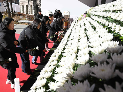 Mourners pay their respects at a memorial altar for the victims of the Jeju Air plane crash, in front of Seoul City Hall in Seoul on December 31, 2024.  