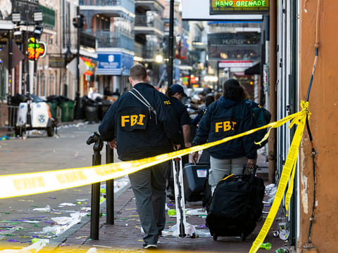 FBI investigators arrive at the scene where the white Ford F-150 pickup truck that crashed into a work lift.