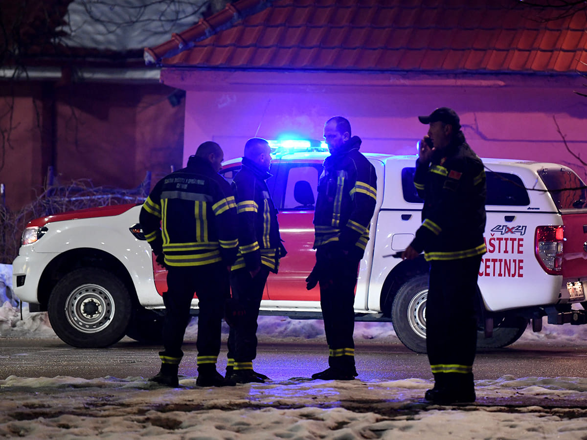 Police officers and civil protection units secure a crime scene after a gunman killed 10 people in the village of Bajice near Cetinje, Montenegro, on January 1, 2025. 