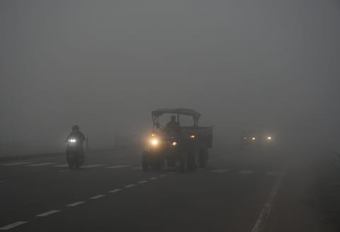 Vehicles ply on roads amid the fog on a cold winter day, in Kanpur. 
