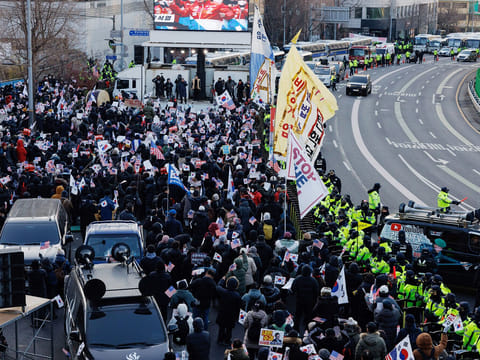 Police officers stand guard as supporters of South Korean President Yoon Suk Yeol gather near the presidential residence in Seoul, South Korea, on Friday, January 3, 2025. 