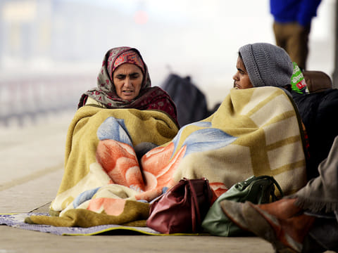 Passengers wait for their train on a cold winter morning, at Jalandhar railway station on Thursday, January 2, 2025. 