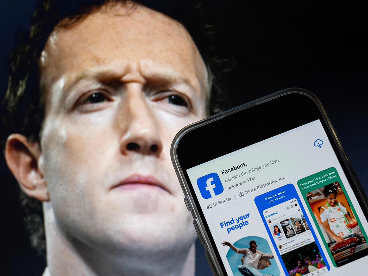This photo illustration shows an image of Mark Zuckerberg, CEO of Meta, and a phone displaying the download page for the Facebook app. US media reported that Meta slashed 5% of its workforce – in a move CEO Mark Zuckerberg previously framed as a drive for "stronger talent."