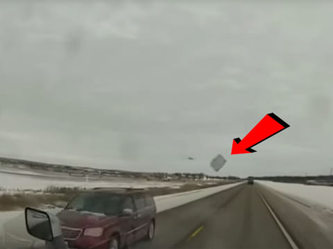 A flying ice chunk flew off the top of a van into the truck's windshield.