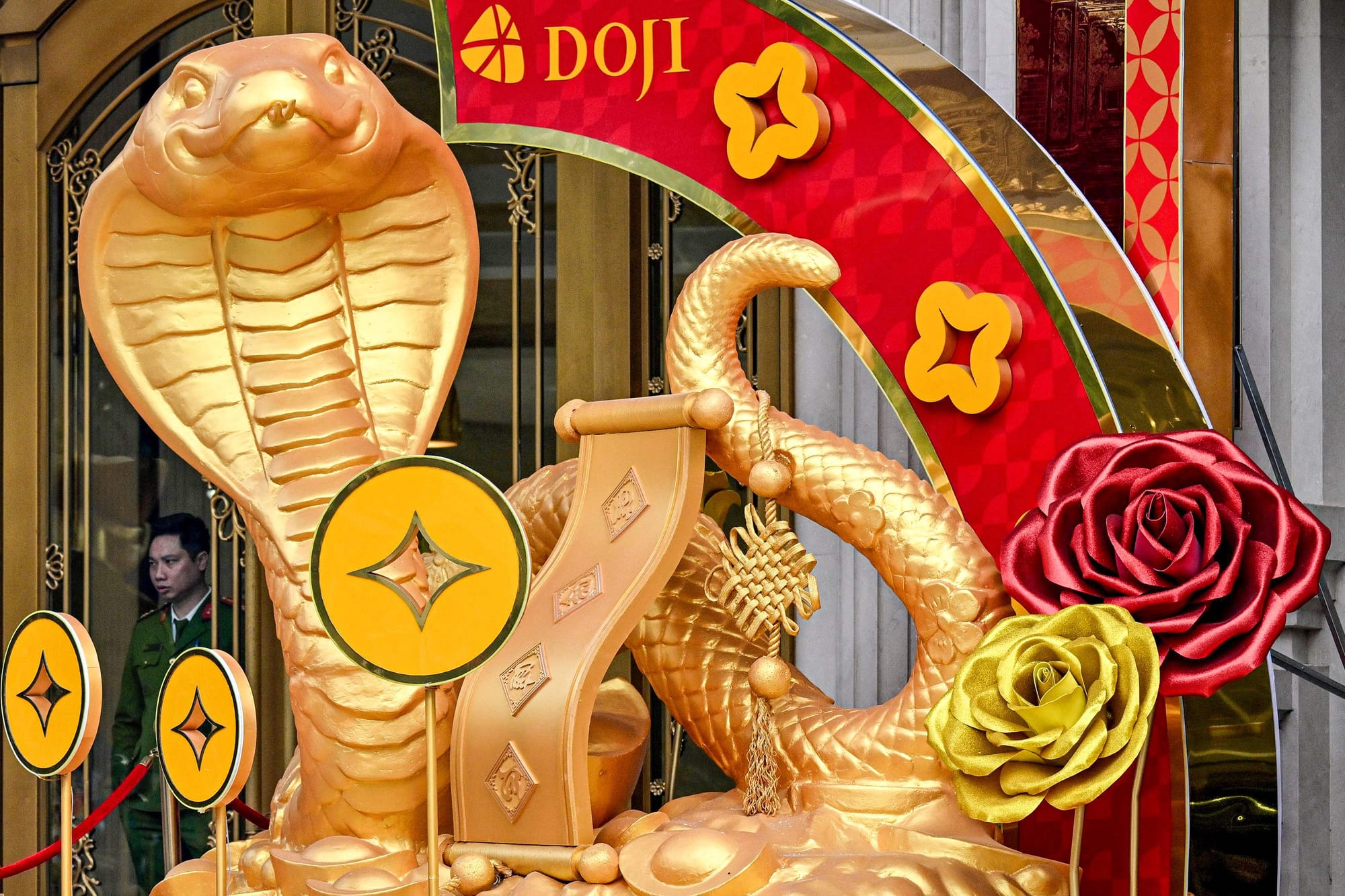 A police officer (L) stands behind snake decorations displayed ahead of the upcoming Chinese New Year, marking the Year of the Snake, in Hanoi on January 15, 2025.
