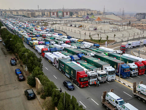 Trucks that are part of a humanitarian aid convoy carrying shipments to Palestinians in the Gaza Strip wait for the convoy to start moving in the Asmarat district in Al Muqattam on the southern outskirts of Cairo on January 26, 2025.  