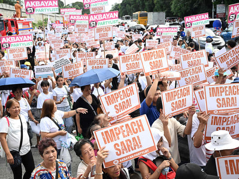 Protesters holding placards shout slogans during a rally at the People Power monument in Manila on January 31, 2025, in support of the impeachment of Philippine Vice-President Sara Duterte. 