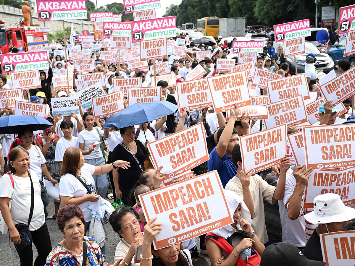 Protesters holding placards shout slogans during a rally at the People Power monument in Manila on January 31, 2025, in support of the impeachment of Philippine Vice-President Sara Duterte. 