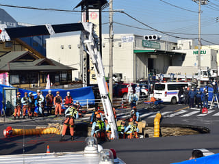 Rescuers build slope to reach man in Japan sinkhole
