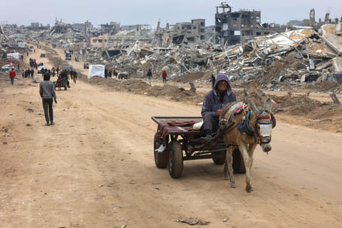 A man rides a donkey-pulled cart past the rubble of destroyed buildings at Saftawi street in Jabalia, in the northern Gaza Strip, on February 5, 2025 during a ceasefire deal in the war between Israel and Hamas.  