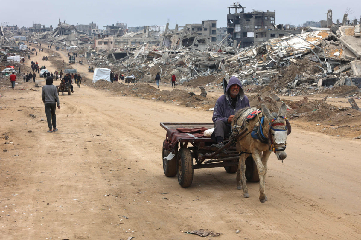 A man rides a donkey-pulled cart past the rubble of destroyed buildings at Saftawi street in Jabalia, in the northern Gaza Strip, on February 5, 2025 during a ceasefire deal in the war between Israel and Hamas.  