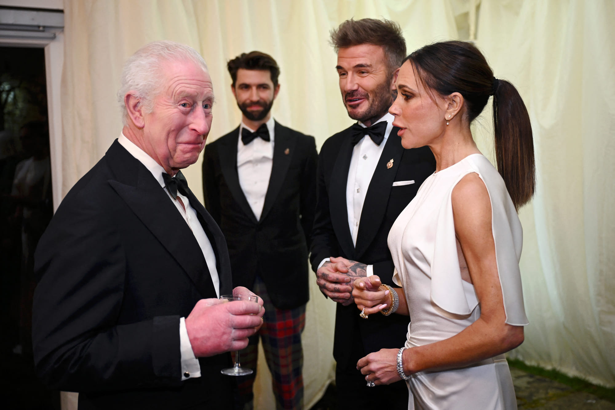 Britain's King Charles III reacts as he meets British fashion designer Victoria Beckham and British Ex-Footballer David Beckham, February 7, 2025.