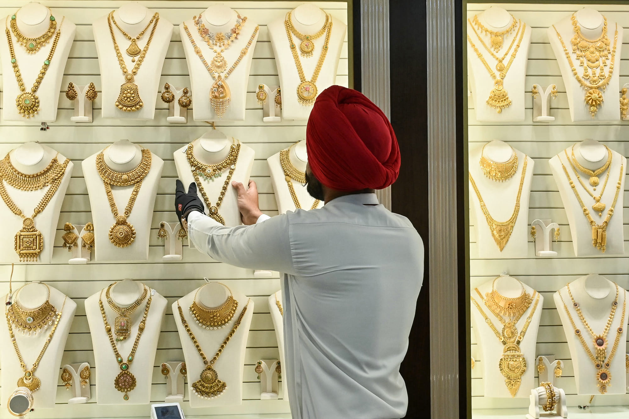An employee arranges gold jewellery kept for display.