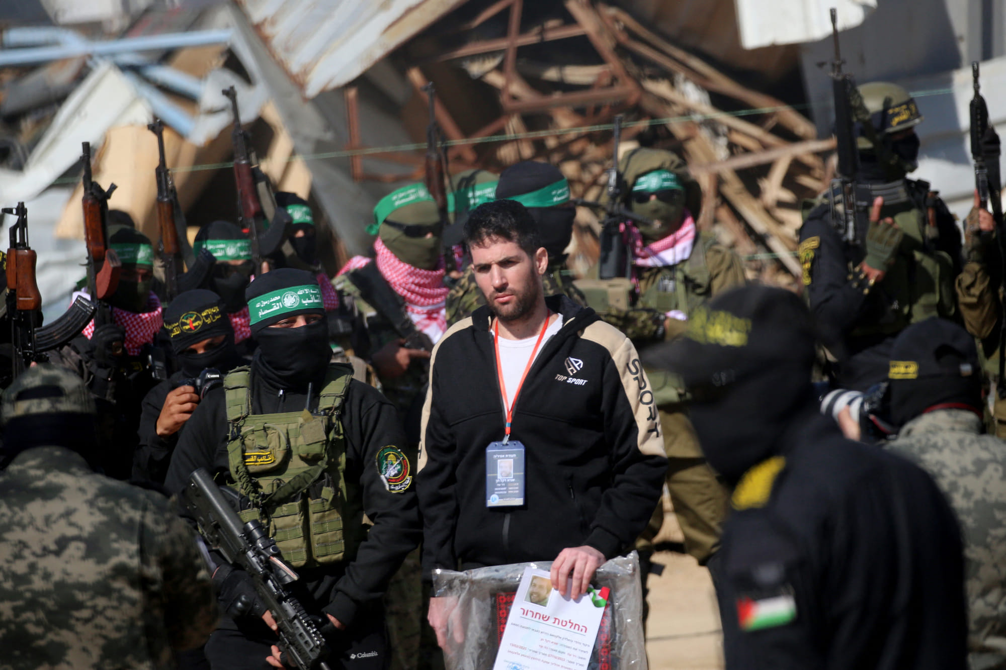 Palestinian militants escort Israeli-American hostage Sagui Dekel-Chen (C) before handing him over to a Red Cross team in Khan Yunis in the southern Gaza Strip on February 15, 2025, as part of the sixth hostage-prisoner exchange.