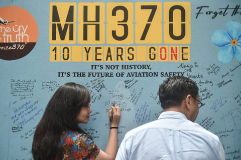 A woman writes a message during an event held by relatives of the passengers and supporters to mark the 10th year since the Malaysia Airlines flight MH370 carrying 239 people disappeared from radar screens on March 8, 2014 while en route from Kuala Lumpur to Beijing, in Subang Jaya on March 3, 2024.