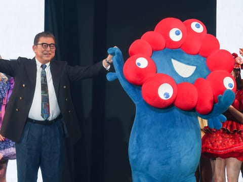 Japan's Prime Minister Shigeru Ishiba (L) stands with Myaku-Myaku (R), the mascot for the 2025 Osaka World Expo, as he models an outfit during a visit to the Tokyo Girls Collection fashion event in the Shibuya district of Tokyo on March 1, 2025.