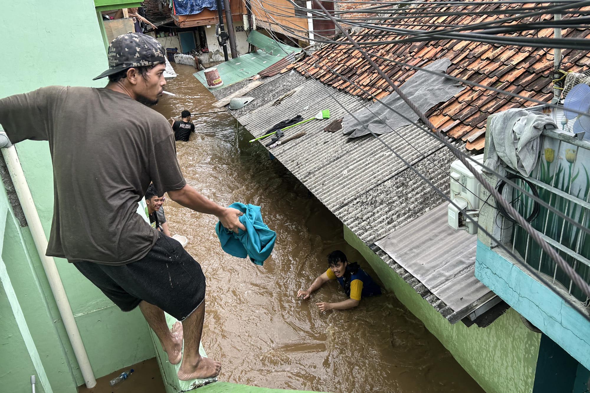 Residents look to evacuate during severe flooding in Jatinegara district in Jakarta.