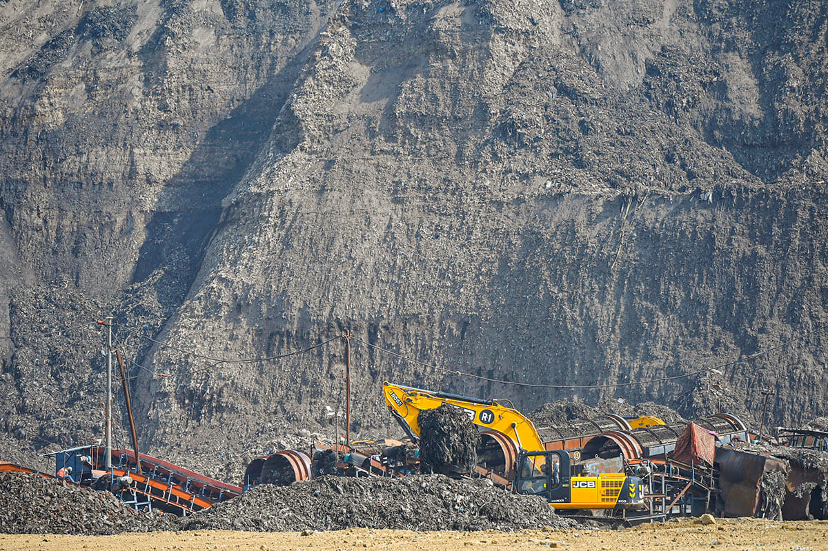 A JCB crane machine clears the garbage at Bhalswa landfill, in New Delhi on Tuesday.