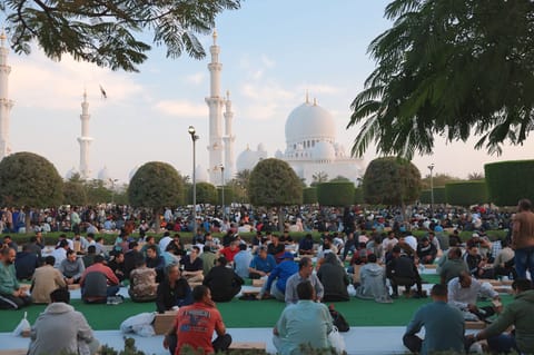 As the sun sets, the mosque’s expansive courtyards transform into a vibrant gathering space, with long rows of tables set up to accommodate thousands of worshippers. 
