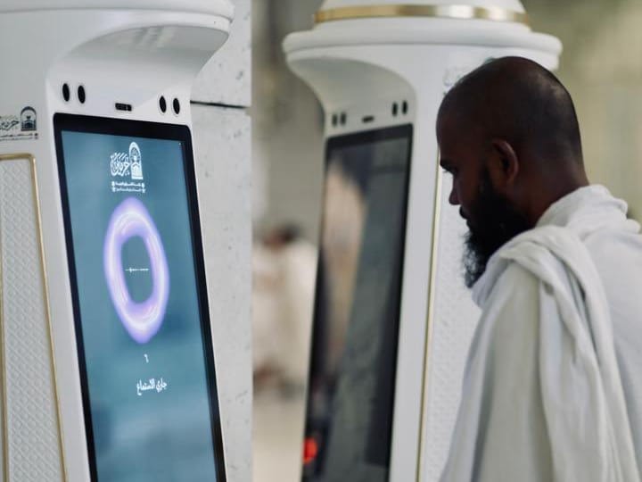 A worshipper approaches the Manara robot introduced in the Grand Mosque. 