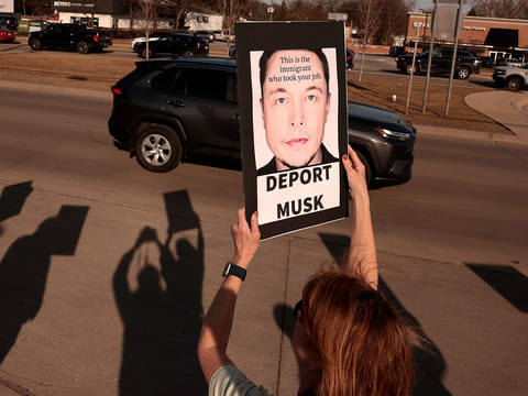 People participate in a protest against Elon Musk outside of a Tesla dealership in West Bloomfield, Michigan on March 13, 2025. 