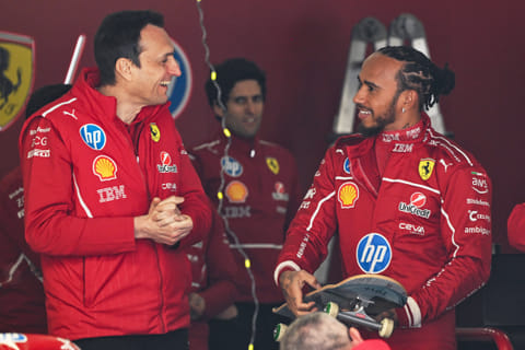 Ferrari's British driver Lewis Hamilton chats with team members while holding a skateboard in the Ferrari pit garage ahead of the Formula One Chinese Grand Prix in Shanghai on March 20.