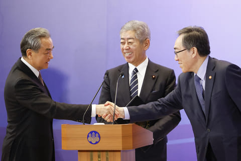 China's Foreign Minister Wang Yi (L) and South Korea's Foreign Minister Cho Tae-yul (R) shake hands as Japan's Foreign Minister Takeshi Iwaya looks on during a joint press conference after their meeting during the 11th Trilateral Foreign Minister's Meeting (Japan-China-ROK) in Tokyo on March 22, 2025.