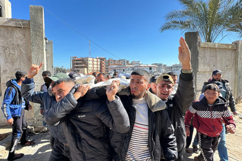 Palestinians carry the body of a relative, killed in Israeli strikes, during their funeral in Khan Yunis in the southern Gaza Strip on March 23, 2025.  