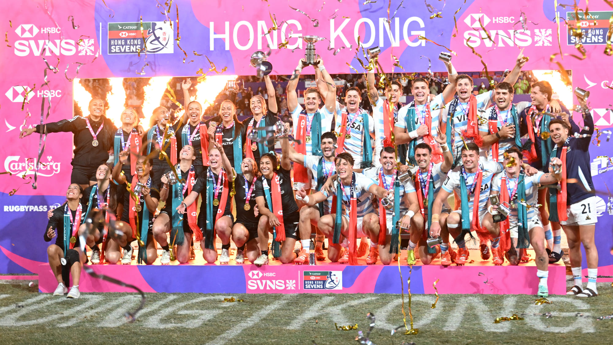 The New Zealand women and Argentina men's teams celebrate with their trophies on the podium after winning their cup finals matches on the third day of the 2025 Rugby Sevens Hong Kong tournament at the Kai Tak sports stadium on March 30.