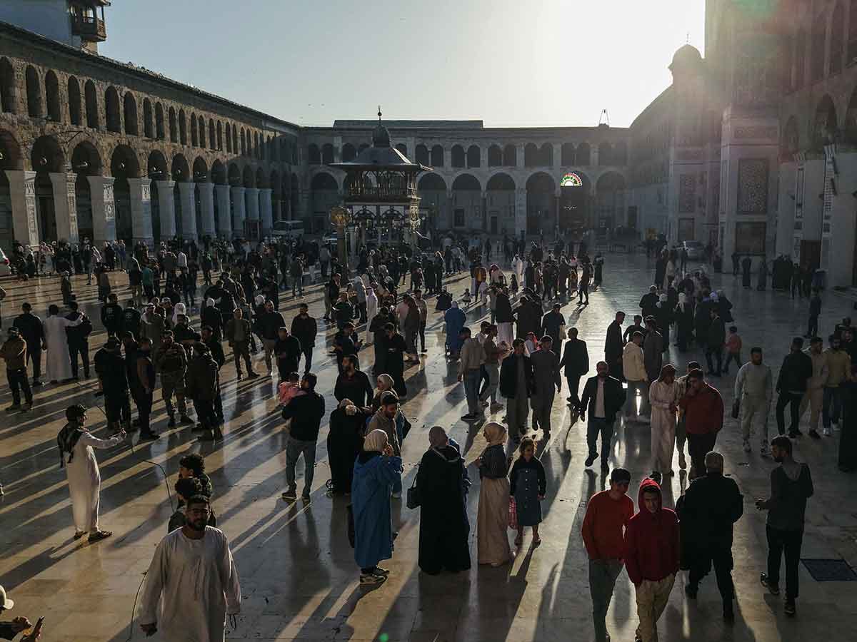 An aerial picture shows people gathering in the Umayyad Mosque courtyard after the morning prayer on the first day of Eid Al Fitr, in Damascus on March 31, 2025.