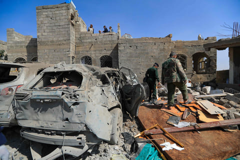 Houthi militants inspect the site of a reported US airstrike in Sanaa, a day after the attack, on April 7, 2025.  
