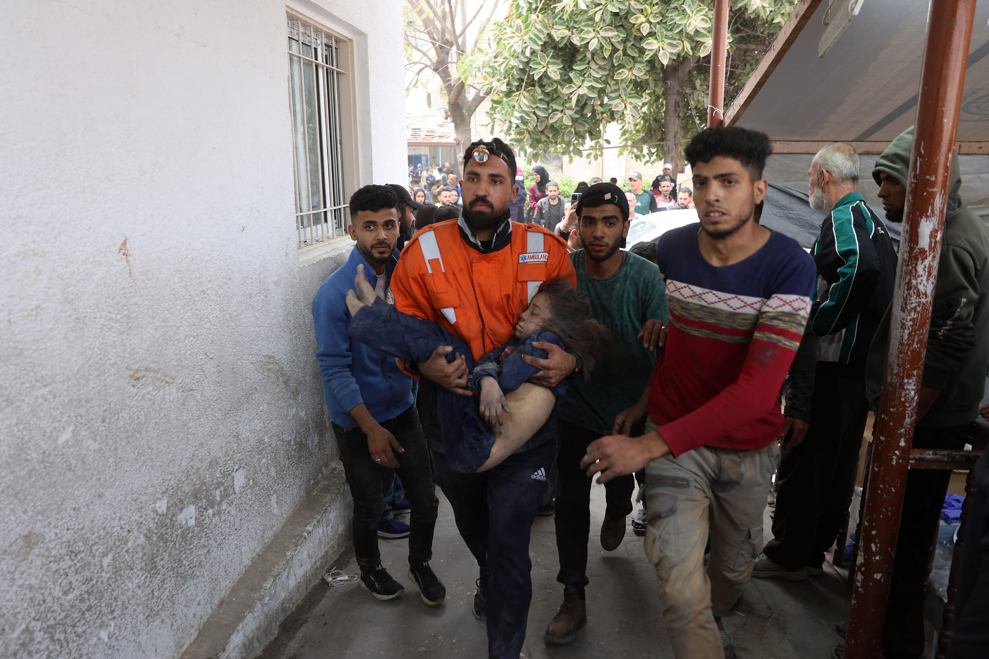 A Palestinian rescuer carries the body of a child killed in an Israeli strike on a residential area in Gaza City's Shujaiyya neighbourhood.