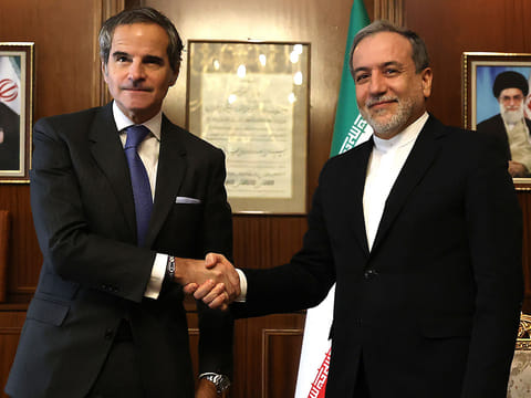 In this file photo taken on November 14, 2024 Iran’s Foreign Minister Abbas Araghchi (R) shakes hands with International Atomic Energy Agency (IAEA) Director General Rafael Mariano Grossi before a meeting in Tehran. UN nuclear watchdog chief Rafael Grossi said on April 14, 2025 he will travel to Tehran this week to discuss cooperation on the country's nuclear programme, saying that diplomatic solutions were "urgently needed". 