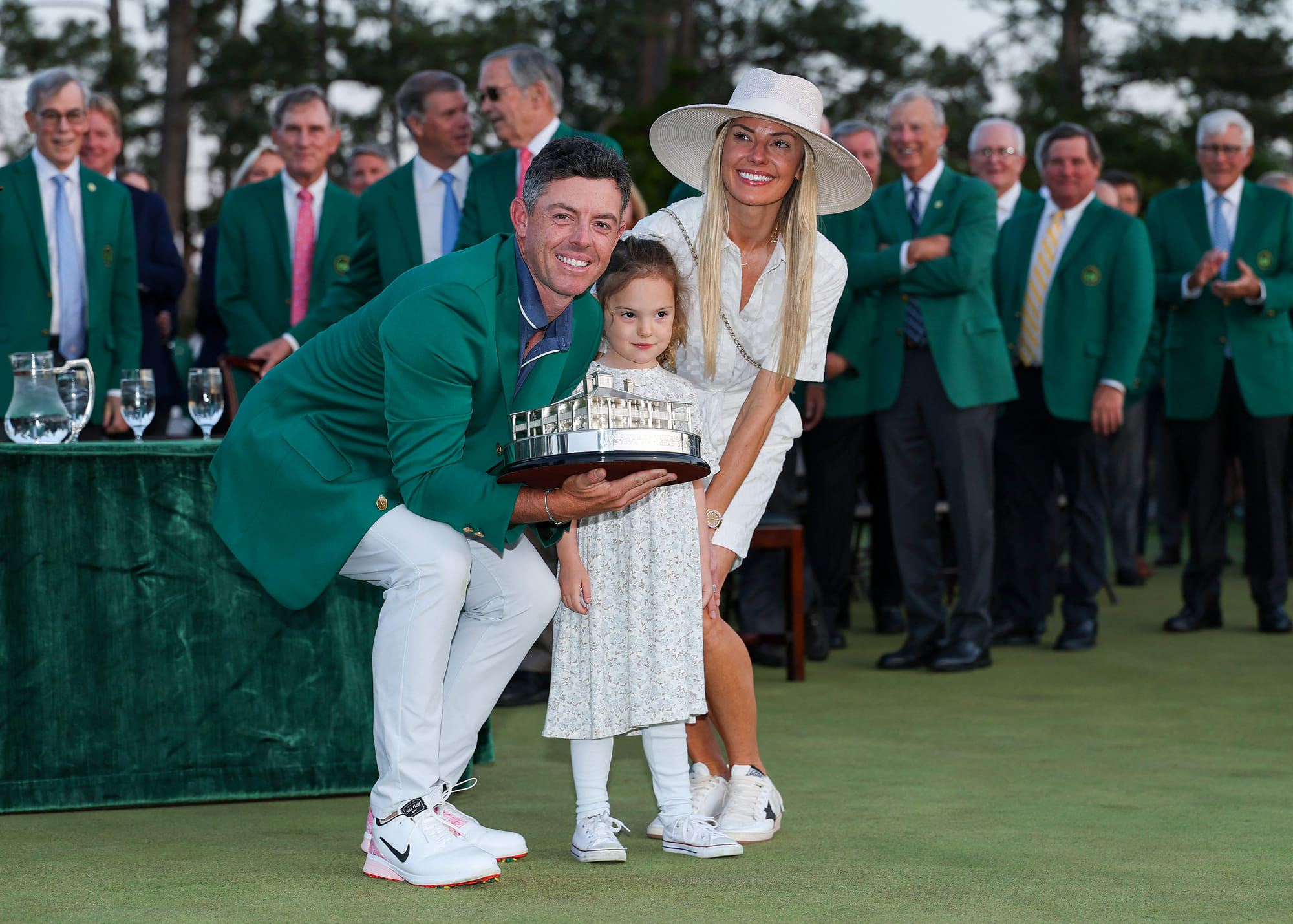 Rory McIlroy of Northern Ireland poses with daughter Poppy and wife Erica Stoll holding the Masters trophy during the Green Jacket Ceremony after winning the 2025 Masters Tournament at Augusta National Golf Club on Sunday.